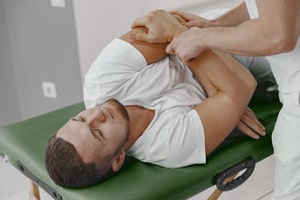 Chiropractor performing spinal adjustment on male patient