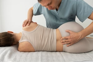 Chiropractor performing prenatal chiropractic adjustment on pregnant woman