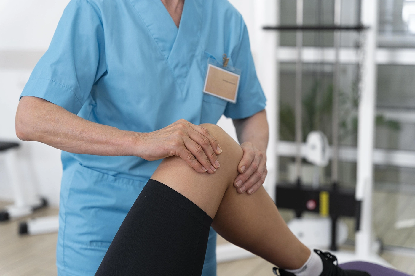 Physiotherapist examining knee during sports injury treatment session.