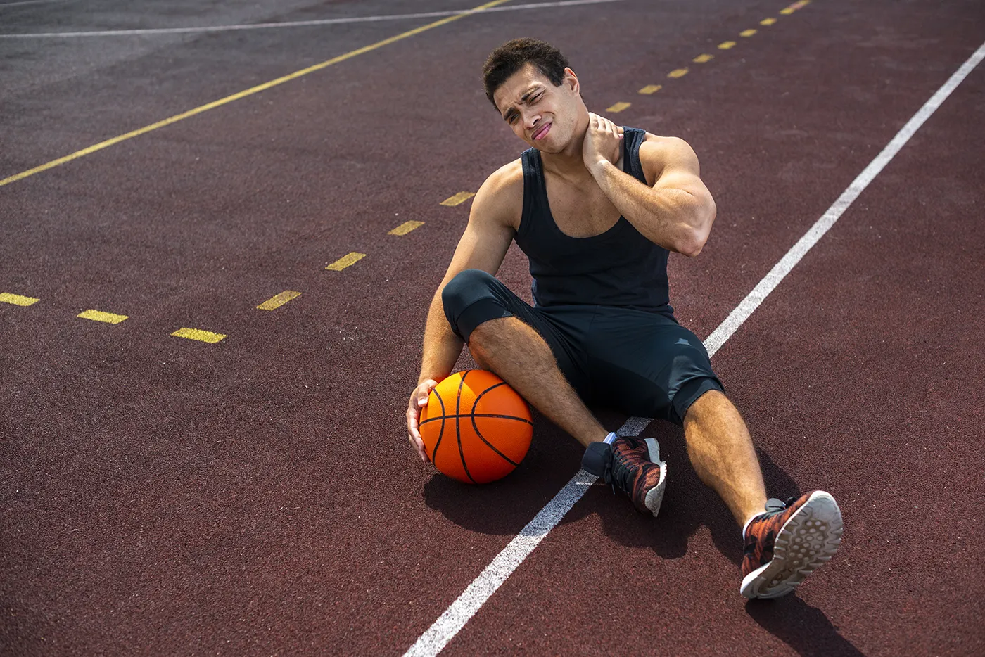Athlete holding his neck in discomfort after basketball practice — back to sports season recovery advice.