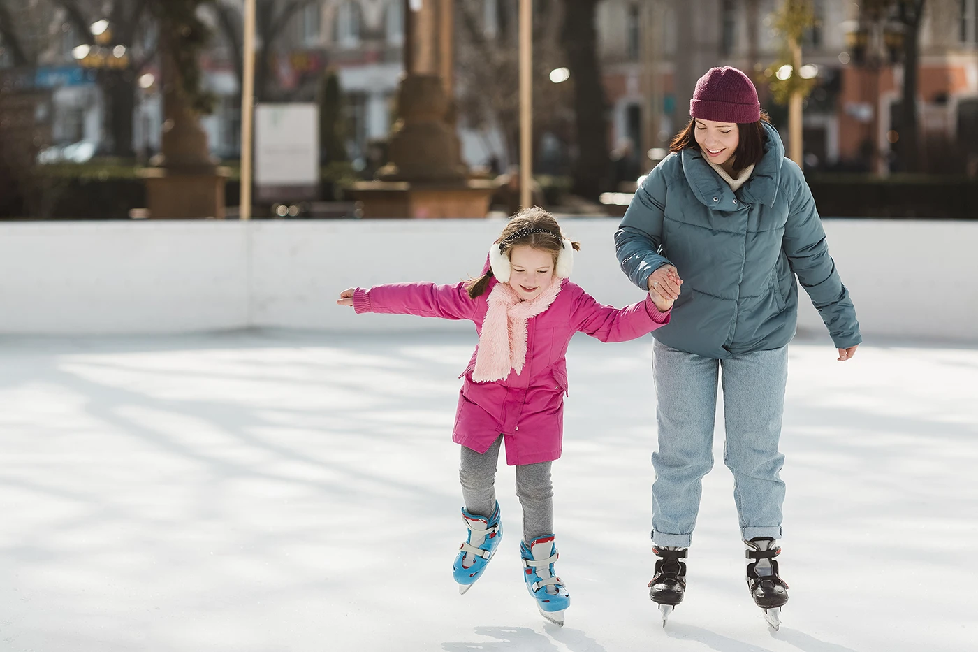 Mother helping child ice skate to prevent typical injuries from winter by Blair Chiropractic & Massage Therapy