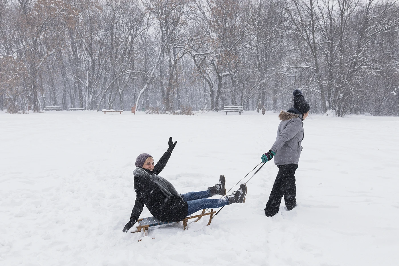 Woman being pulled on sled with focus on avoiding typical injuries from winter by Blair Chiropractic & Massage Therapy