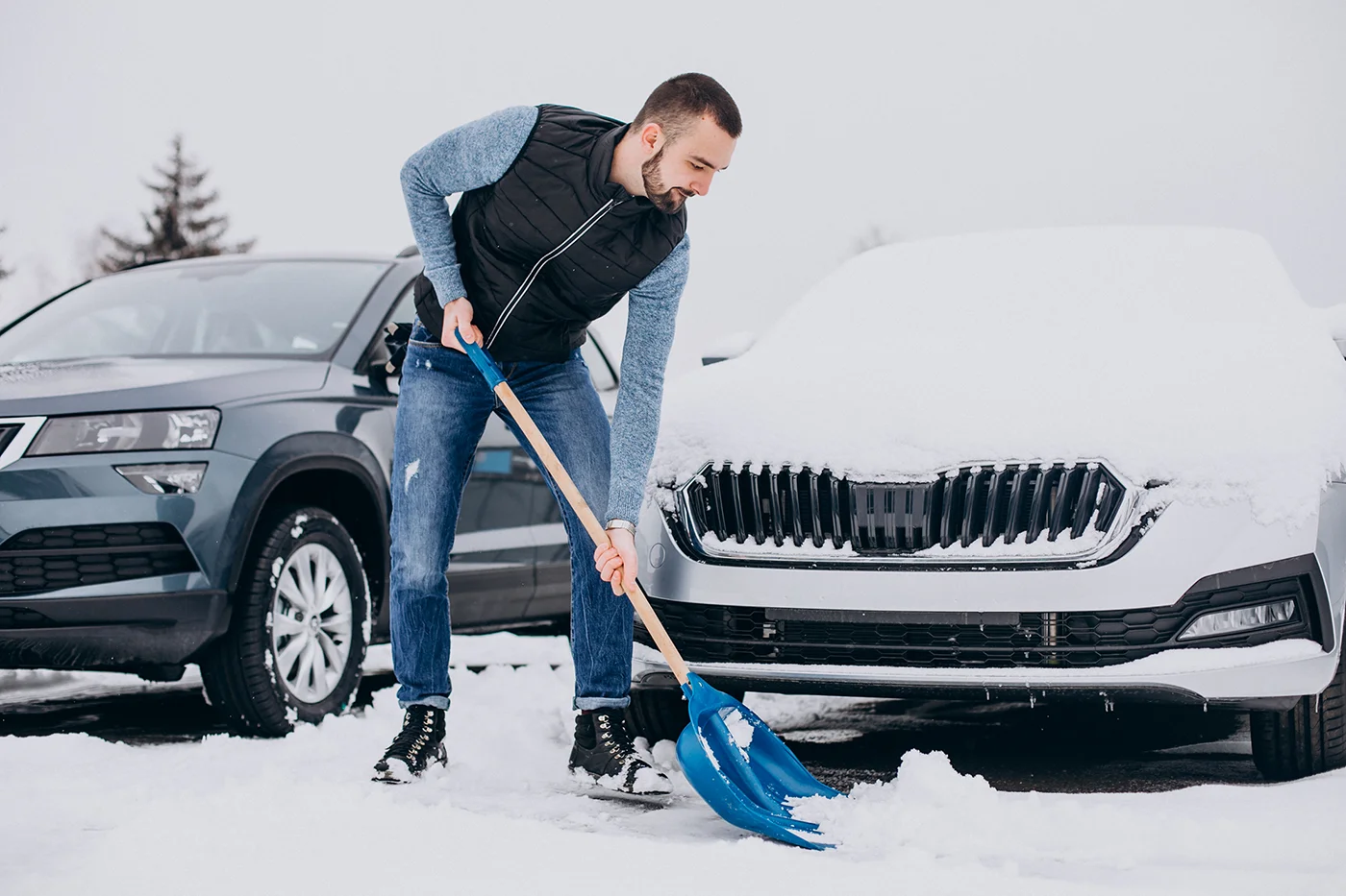 Man clearing snow near a car for snow shovelling safety by Blair Chiropractic & Massage Therapy