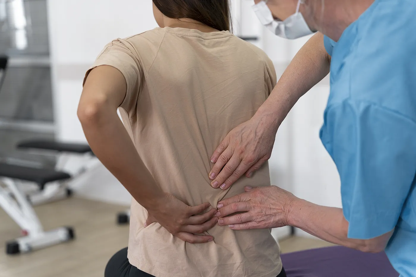 Chiropractor assessing lower back pain in clinic, chiropractic for sciatica at Blair Chiropractic & Massage Therapy